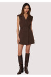 Woman wearing a brown sleeveless dress with matching knee-high boots on a white background
