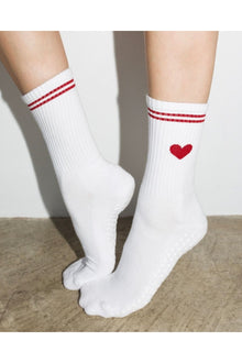  White socks with red stripes and a heart design on a neutral background