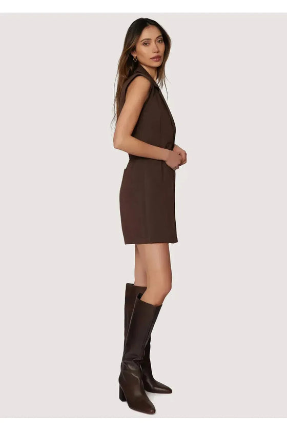Woman wearing a brown dress and knee-high boots on a white background
