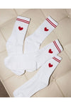 White socks with red hearts and stripes on a tiled floor