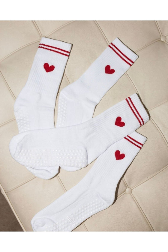 White socks with red hearts and stripes on a tiled floor