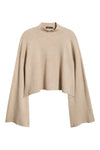A light beige knit poncho-style sweater with a mock neck and wide draped sleeves, shown against a plain white background.