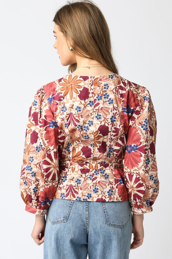 Woman wearing a floral blouse with long sleeves on a white background