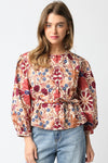 Woman wearing a floral blouse with long sleeves on a white background