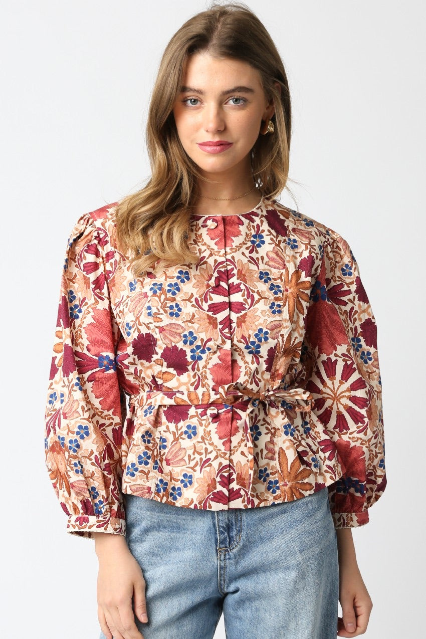  Woman wearing a floral blouse with long sleeves on a white background