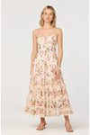 Woman wearing a floral strapless maxi dress on a white background