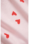 Close-up of pink fabric with red heart patterns. 