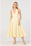 Woman wearing a light yellow halter neck midi dress on a white background. 