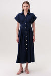 Woman wearing a short sleeve navy midi dress with gold buttons on a white background