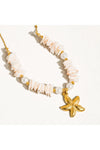 Necklace with starfish charm and pink shell beads on a white background.