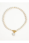 Pearl necklace with a gold clasp and white heart on a white background. 